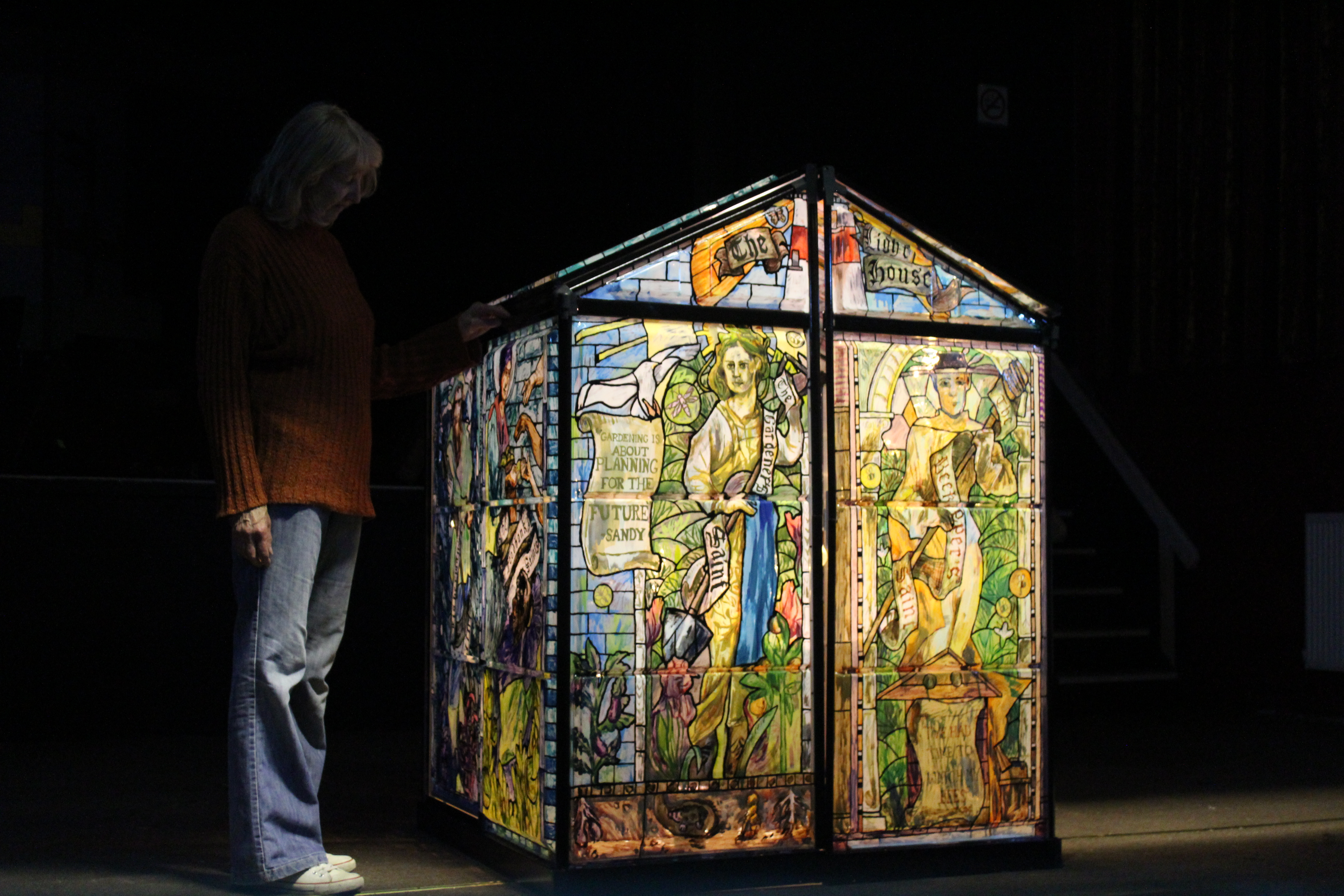 A photo of a stained glass house illuminated from the inside