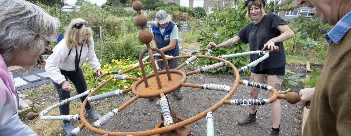 a group of people operate a large digging machine made out of metal