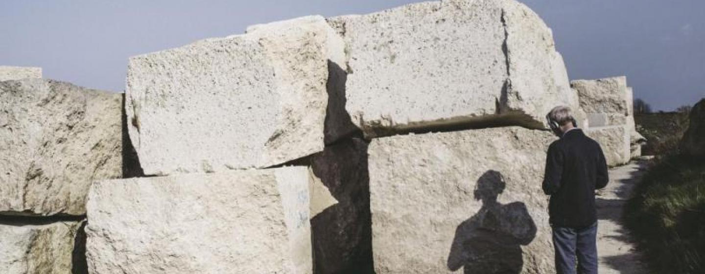 man looking at stone