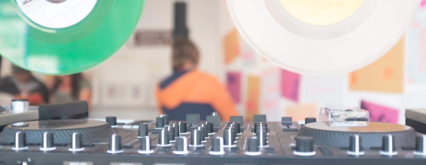 A DJ deck with some records hanging above for decoration