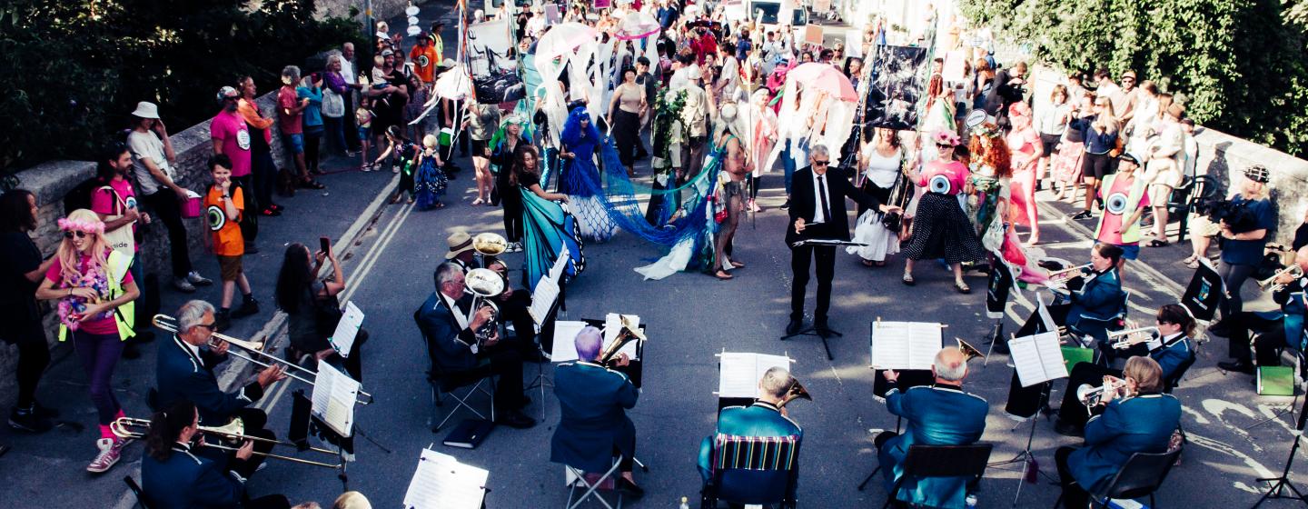 An image of The Big Portland Parade in a crowd, dancing to a brass band