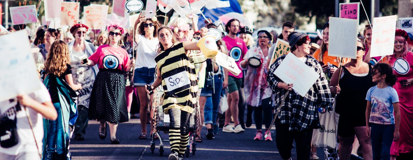 A group of people in costumes walking through the streets of Portland