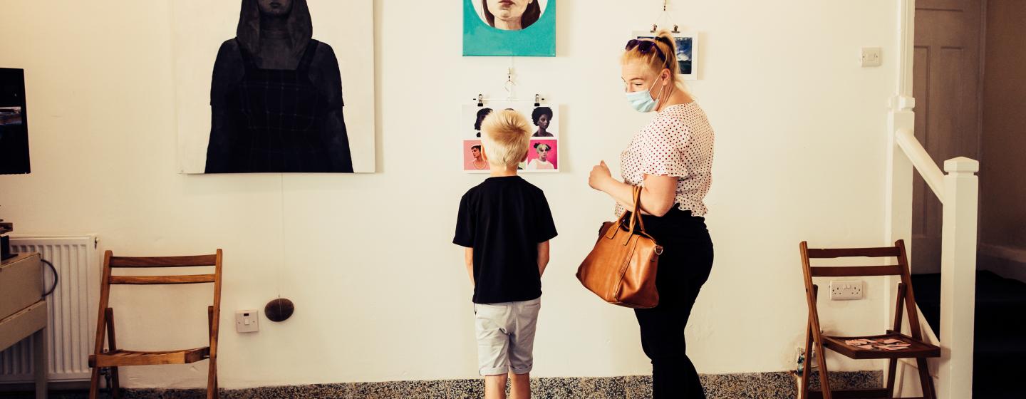 A woman and child looking at artwork on the walls