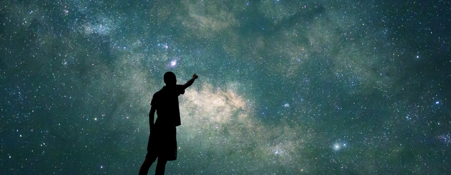 A photograph of the night sky with a person in silhoette