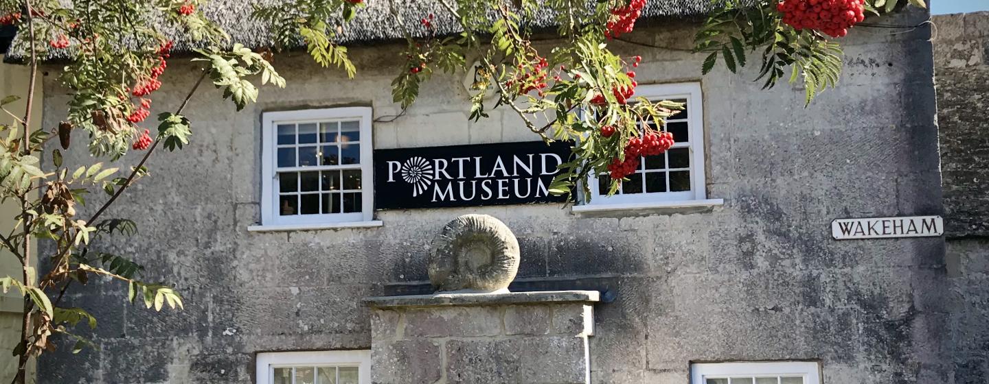 A stone building with Portland Museum sign
