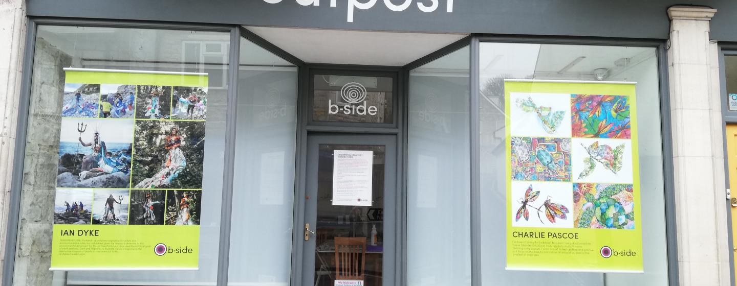 A photograph of the outside of the b-side project space on Portland exhibitiing large colourful posters created by Portland residents