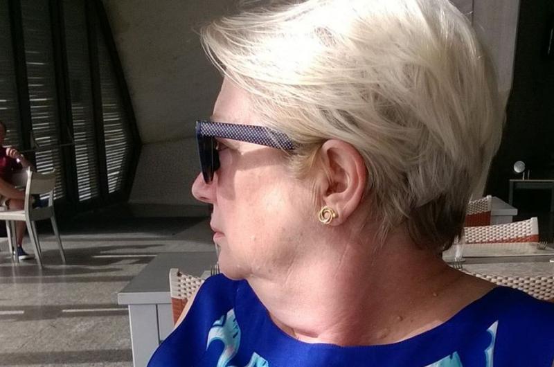 A picture of a woman in a blue top and sunglasses