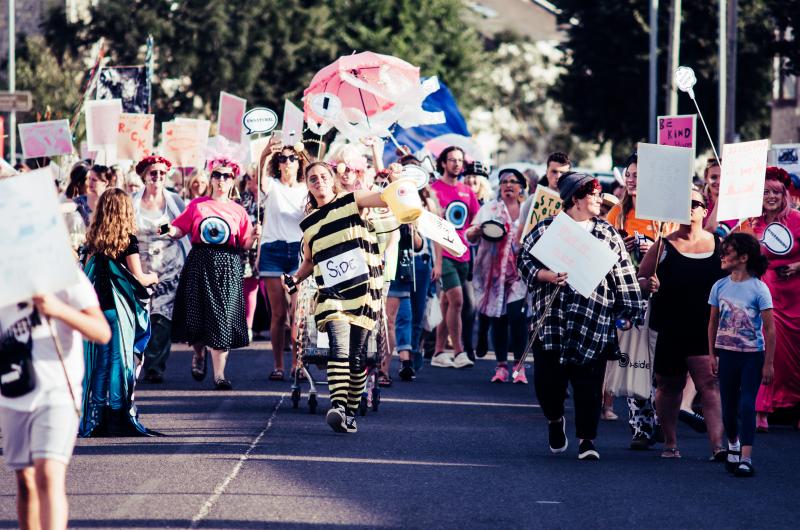 A colourful and lively image of a group of people dressed in fancy dress costume parading through the street at b-side 2021 Photo: Pete Millson