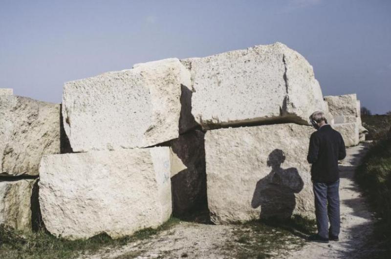 man looking at stone