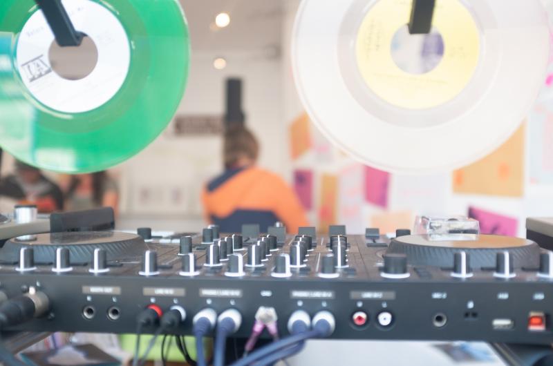A DJ deck with some records hanging above for decoration