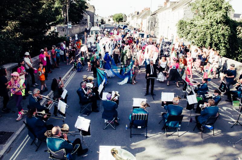 An image of The Big Portland Parade in a crowd, dancing to a brass band