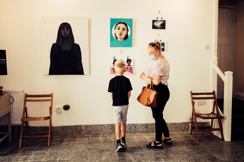 A woman and child looking at artwork on the walls
