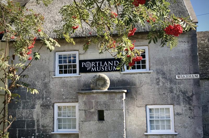 A stone building with Portland Museum sign