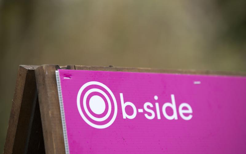 A pink board with the word 'b-side' written on it