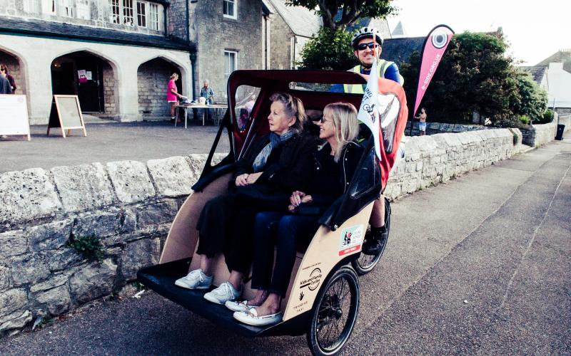 Two people on a Trishaw bike, in front of the b-side Festival Hub