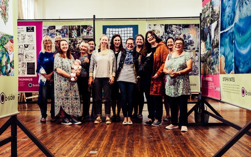 A group of people standing in front of an exhibition of large posters