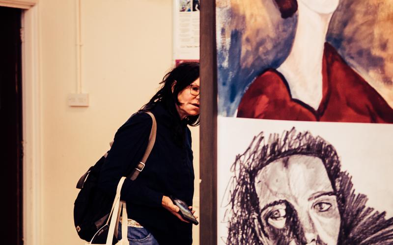 A woman looking at an exhibition of large posters