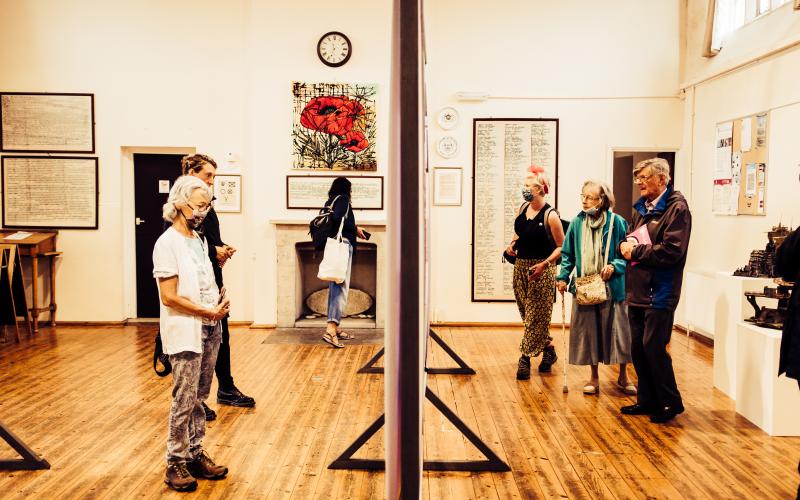Several people looking at an exhibition of large posters