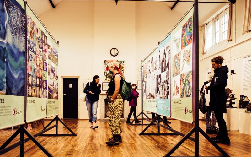 Several people looking at an exhibition of large posters