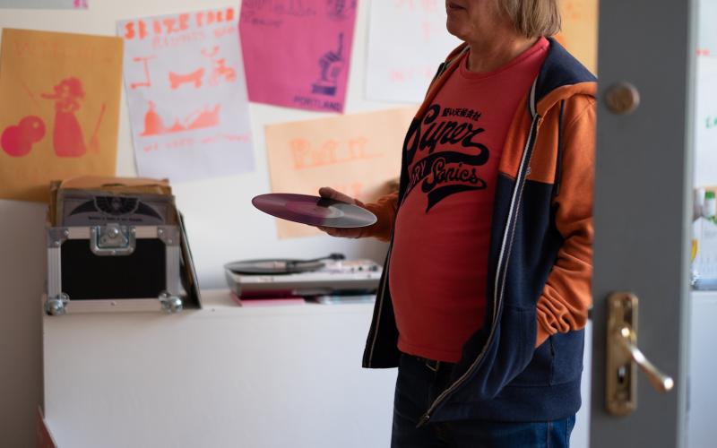 A man standing and holding a record