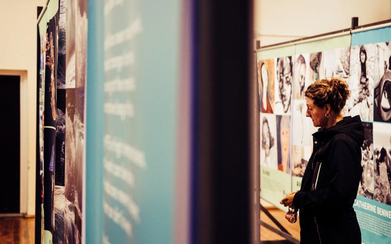 A woman looking at an exhibition of large posters