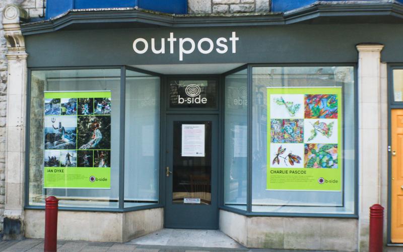 Two large shops windows displaying large posters 